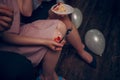 Close up of girl`s hand holding a fork with a piece of cake on her knees