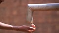 Close up of a girl's hand reaching out for water at the village pump station