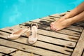 Close-up of a girl`s legs resting near the pool. The girl took off her shoes and relaxes Royalty Free Stock Photo