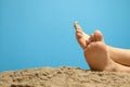 Close-up on a girl's soles at the beach, the girl sits on sand with crossed legs Royalty Free Stock Photo