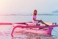 Close-up of a girl on a small boat moored at sunset, tinted Royalty Free Stock Photo