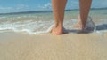 CLOSE UP Girl on awesome summer vacation on paradise beach soaks her feet in sea Royalty Free Stock Photo