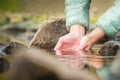 Close-up of a girl& x27;s hands and water from a mountain lake, nature, a clean source of water to quench thirst