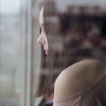 Close up on girls face behind the window looking outside during epidemic lock down Royalty Free Stock Photo