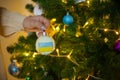 a girl holds a decoration on a Christmas tree with the flag of Ukraine Royalty Free Stock Photo