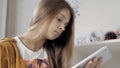 Close up of girls hands typing on tablet at homework session. Female little student at home