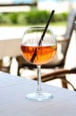 Close up of a glass of aperol spritz or campari orange cocktail with orange slice and ice on a restaurant table on the seashore on Royalty Free Stock Photo