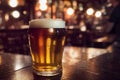 Close up of a small glass of beer with blurred background on a table with reflection Royalty Free Stock Photo
