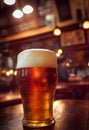 Close up of a wide glass of beer with blurred background on a table with reflection Royalty Free Stock Photo