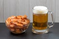 Close up of a glass of beer and shrimp in a glass bowl on a dark stone background. Horizontal photo, macro, selective focus. Royalty Free Stock Photo