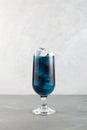 Close-up glass of blue lagoon cocktail. Tall glass of refreshing drink on light grey background. Vertical orientation, copy space Royalty Free Stock Photo