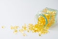 Close-up of glass bottle lying down with evening primrose oil pills, on white background with pills, Royalty Free Stock Photo