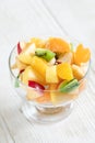 Close-up glass bowl with fruit salad on white wooden table. Royalty Free Stock Photo