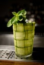 Close-up of glass braided with green cucumber with a sprig of fresh mint