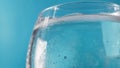 Close-up of a glass of cold water with condensation on a blue background Royalty Free Stock Photo