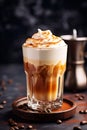 Close-up of a glass of Dalgona Coffee with cinnamon on dark background, vertical image of homemade coffee drink. Coffee latte made