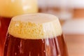 Close up of glass of dark beer with foam in a blurred background Royalty Free Stock Photo