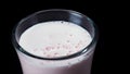 Close up for a glass full of strawberry milkshake isolated on black background. Frame. Pink smoothie in a jar, healthy Royalty Free Stock Photo