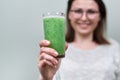 Close up glass with green natural vegetable smoothie drink in woman`s hand Royalty Free Stock Photo