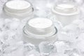 Close-up of glass jar with cream surrounded by ice cubes Royalty Free Stock Photo