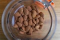 Close up of glass jar full of almond seeds on wood table background