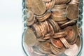 Close up of a glass jar full of coins on a white background Royalty Free Stock Photo