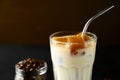 Close-up glass with milk and ice cubes made from coffee. Iced coffee with a metal tube on a brown background. Royalty Free Stock Photo