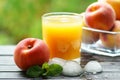 Close-up of a glass of peach juice with ice with a whole peach