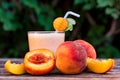 Glass of peach yoghurt and peaches on wooden table Royalty Free Stock Photo