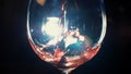 Close-up of glass pouring with red sparkling wine in the dark with white light on the background. Stock footage. View of Royalty Free Stock Photo