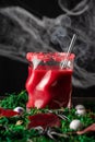 Close-up of glass with red halloween cocktail, on table with leaves, spiders and eyes, black background with spider web Royalty Free Stock Photo