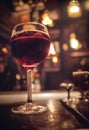 Close up of a glass of red whine with blurred background on a table with lights