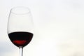 Close-up of a glass glass of red wine against a blurred background of the sky and sunset in the evening. Concept of romantic Royalty Free Stock Photo