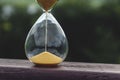 Glass sand watch on wooden background in nature. Royalty Free Stock Photo