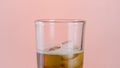 Close up of a glass with soda water and ice cubes. Action. A soft drink with many bubbles inside the transparent glass Royalty Free Stock Photo