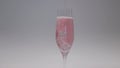 Close-up of a glass with sparkling rose wine and ice, on a white background.