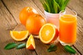 Close-up of Glass squeezed orange juice and fresh fruits ripe cut half, slice with green leaves on old wood vintage table. Breakfa Royalty Free Stock Photo