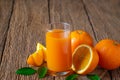 Close-up of Glass squeezed orange juice and fresh fruits ripe cut half, slice with green leaves on old wood vintage table. Breakfa Royalty Free Stock Photo