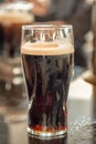 Close up of a glass of stout beer on a bar counter