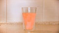 Close up of glass of water and a effervescent tablet, close up. Concept. Round orange painkiller pill, medical concept