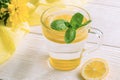 Close-up glass of water with lemon and mint on wooden table with yellow cloth. Royalty Free Stock Photo