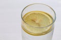 Close-up glass of water with lemon slice on white table background. Top view, copy space. Summer refreshing cool drink. Royalty Free Stock Photo