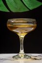 Close-up of glass of whiskey sour, on white marble table, selective focus, black background with green leaf, Royalty Free Stock Photo