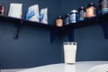 Close up of glass with white cocktail and straw. Protein shake on the counter in sports bar. Banks with sports nutrition on