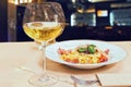 Close up of glass with wine near tasty spaghetti pasta in a rest Royalty Free Stock Photo