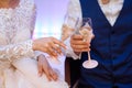 Close up glasses of champagne in hands of bride and groom in wedding day Royalty Free Stock Photo