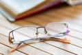 Open book and glasses on wooden table close Royalty Free Stock Photo