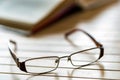 Open book and glasses on wooden table close Royalty Free Stock Photo