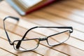 Open book and glasses on wooden table close Royalty Free Stock Photo