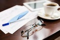 Close up of glasses, tablet pc, charts and coffee